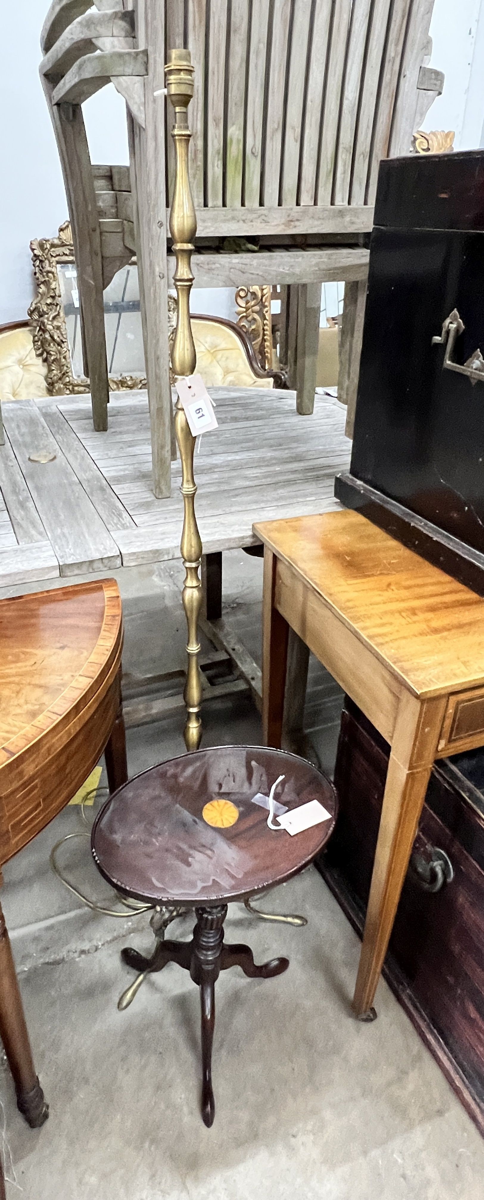 A brass standard lamp on scrolled supports and an oval top mahogany tripod wine table